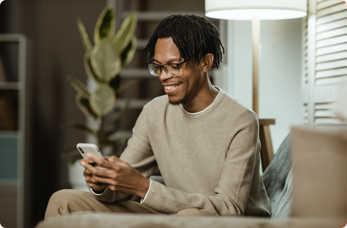 Homem negro usando celular com moleto bege